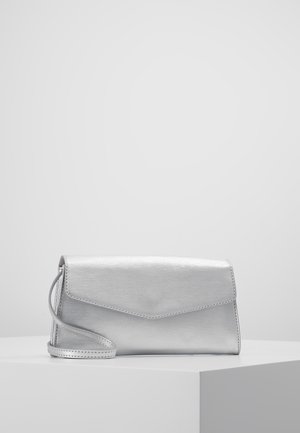 Sølvfarvet rektangulær clutch-taske med klaplukning og en slank håndledsrem, placeret på en hvid piedestal mod en ensfarvet baggrund.