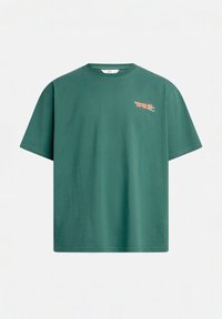 Green cotton t-shirt with a crew neck, short sleeves, and a small multicolored graphic text printed on the left chest area.