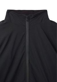 Giacca soft-shell nera con colletto alto e zip frontale, realizzata in tessuto morbido e leggero con finitura opaca.