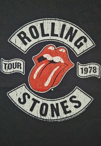 Sort t-shirt med et slidt grafisk motiv af røde læber med en tunge, omgivet af hvid tekst, der står "ROLLING STONES TOUR 1978."