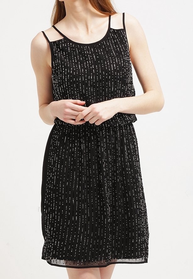 Czarna sukienka z dopasowanym korpusem i luźną spódnicą, ozdobiona pionowymi srebrnymi koralikami oraz cienkimi ramiączkami.