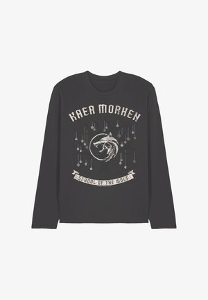 Black long-sleeve shirt with distressed white text "Kaer Morhen" above a wolf emblem and "School of the Wolf" on a banner beneath it.