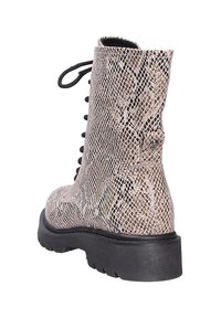Botte à lacets beige et noire avec un motif peau de serpent, semelle épaisse noire, vue de dos et légèrement de côté.
