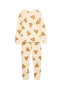 Børne pyjamas sæt i cremefarve med et gentaget bjørnemønster. Lange ærmer og bukser med elastiske manchetter sikrer en tætsiddende pasform.