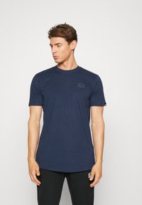 Mørkeblå kortærmet t-shirt med rund hals i blødt stof. Har et diskret logo på brystet og en standard pasform, der er velegnet til afslappet brug.