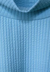 Maglione azzurro chiaro lavorato a maglia con una texture a coste e un colletto ripiegato. Presenta linee verticali e una finitura morbida.
