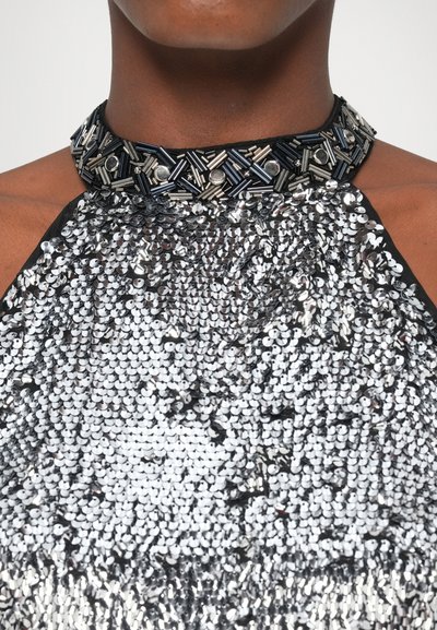 Haltertop mit Pailletten und einem Kragen, der mit schwarzen und metallischen Perlen verziert ist. Verfügt über silberne Pailletten auf dem Oberteil, mit glatter Textur und reflektierender Oberfläche.