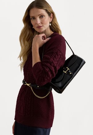Burgundijas adīts džemperis ar garām piedurknēm, apvienots ar melnu plecu somu ar zelta krāsas aizdari un ķēdes detaļu.