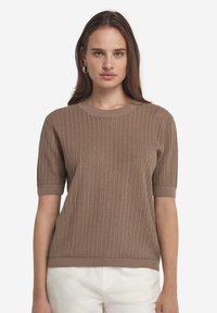 Kurzarm-Strickpullover in Hellbraun mit gerippter Textur, rundem Halsausschnitt und kontrastierenden Bündchen an Saum und Ärmeln.