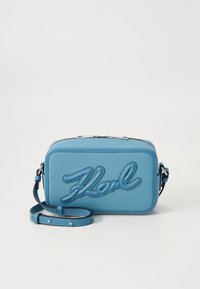 Himmelblå läderväska med över axeln, präglad "Karl"-logga, rektangulär form, dragkedjestängning och justerbar rem med nitar.