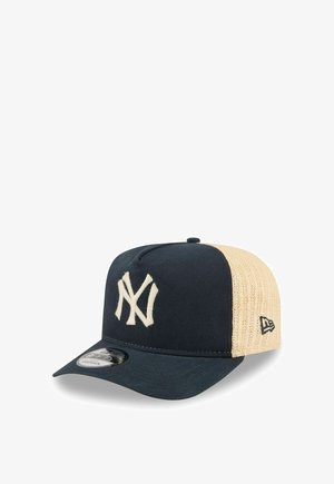 Baseballpet van marineblauw en beige mesh met wit verweven NY-logo aan de voorkant en New Era-logo op de zijkant.