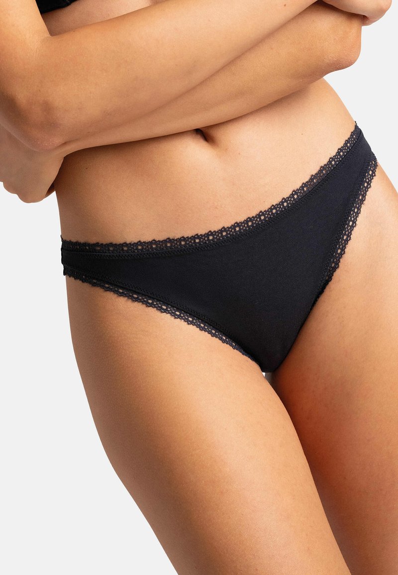 Culotte en coton noir avec une délicate bordure en dentelle le long de la ceinture, texture lisse et coupe ajustée, offrant une couverture complète.