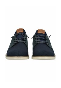 Scarpe di rete blu navy con un design bicolore, caratterizzate da un accento in pelle marrone sul tallone, lacci tondi e una suola in gomma beige.