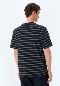 Kortærmet navy T-shirt med hvide vandrette striber, lavet af blødt bomuld, med en afslappet pasform og rund halsudskæring.