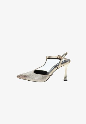 Sandalia de tacón alto dorada con puntera puntiaguda, correa en el tobillo y adornos brillantes de pedrería en la parte delantera.