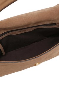 Brown suede handbag interior with a dark fabric lining, featuring a zip pocket and a gold button closure.