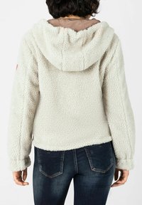 White, fluffy, fleece hoodie with a large hood and long sleeves. Features a textured surface and a slight crop at the waist.