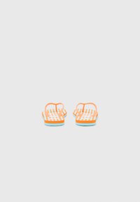 Chinelo à rayures orange et blanches avec une semelle bleue, présentant un design simple et des sangles minimalistes pour un enfilage facile.