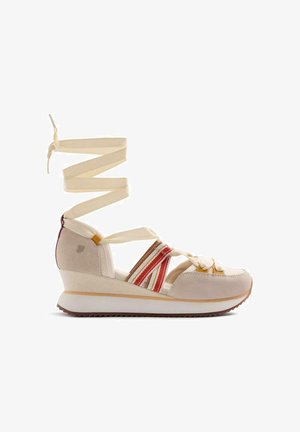 Sandalia cuña beige con tiras de tela a rayas rojas y blancas, cordones crema para atar en el tobillo y suela de goma blanca.