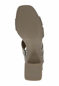 Aukštakulniai sandalai su metalizuotu sidabro spalvos skersiniu dirželiu. Yra tekstūruota šviesiai ruda pado dalis ir kvadratinė bloko pakulnė.