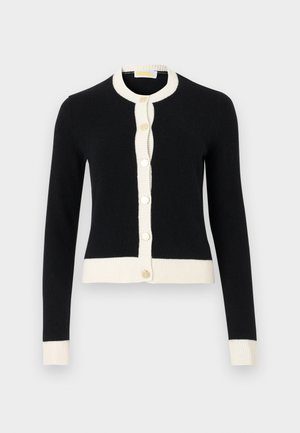 Melnā kardigana ar ribota balta apkakli un aprocēm, ar pogām uz priekšu un apaļām zelta pogām. Gluda tekstūra, pieguļoša forma.