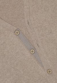 Jasnobrązowa koszula polo z dekoltem w serek, wyposażona w cztery guziki, o teksturowanym splocie i kontrastowym, paskowanym wykończeniu przy zapięciu.