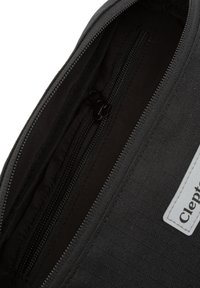 Schwarze Reißverschluss-Tasche, die Reißverschlüsse im Inneren und ein Etikett mit dem Markennamen "Cleptra" zeigt, vor einem dunklen Hintergrund.