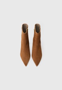 Stivaletti alla caviglia in suede marrone con punta a punta e cerniera laterale. Tessuto liscio con un design aderente, adatti per abbigliamento formale o casual.