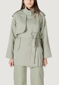 Trench coat verde chiaro con colletto alto, vita con cintura, tasche laterali e design accorciato. Realizzato in tessuto liscio e resistente.