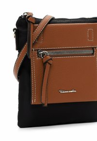 Borsa a tracolla marrone e nera con fronte in pelle textured, hardware in argento, tasca con zip e tracolla regolabile. Presenta dettagli di cucitura bianca.