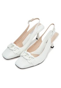 Escarpins blancs à bride arrière avec bouts carrés, talons blocs et détail décoratif en chaîne sur les brides avant.