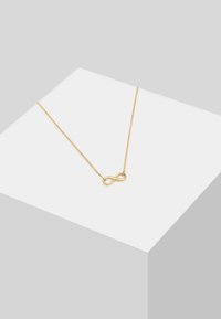Collana d'oro con pendente a simbolo dell'infinito, caratterizzata da una finitura liscia e lucida e una catena delicata. Design semplice ed elegante.