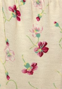 Tkanina w kwiatowy wzór z różowymi i zielonymi kwiatami na beżowym tle, o miękkiej teksturze i delikatnym połysku.