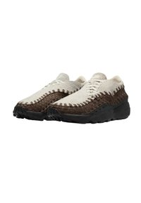 Ljusgrå och brun vävd tygsneaker med en strukturerad design, med en svart gummisula och en lågprofilform.