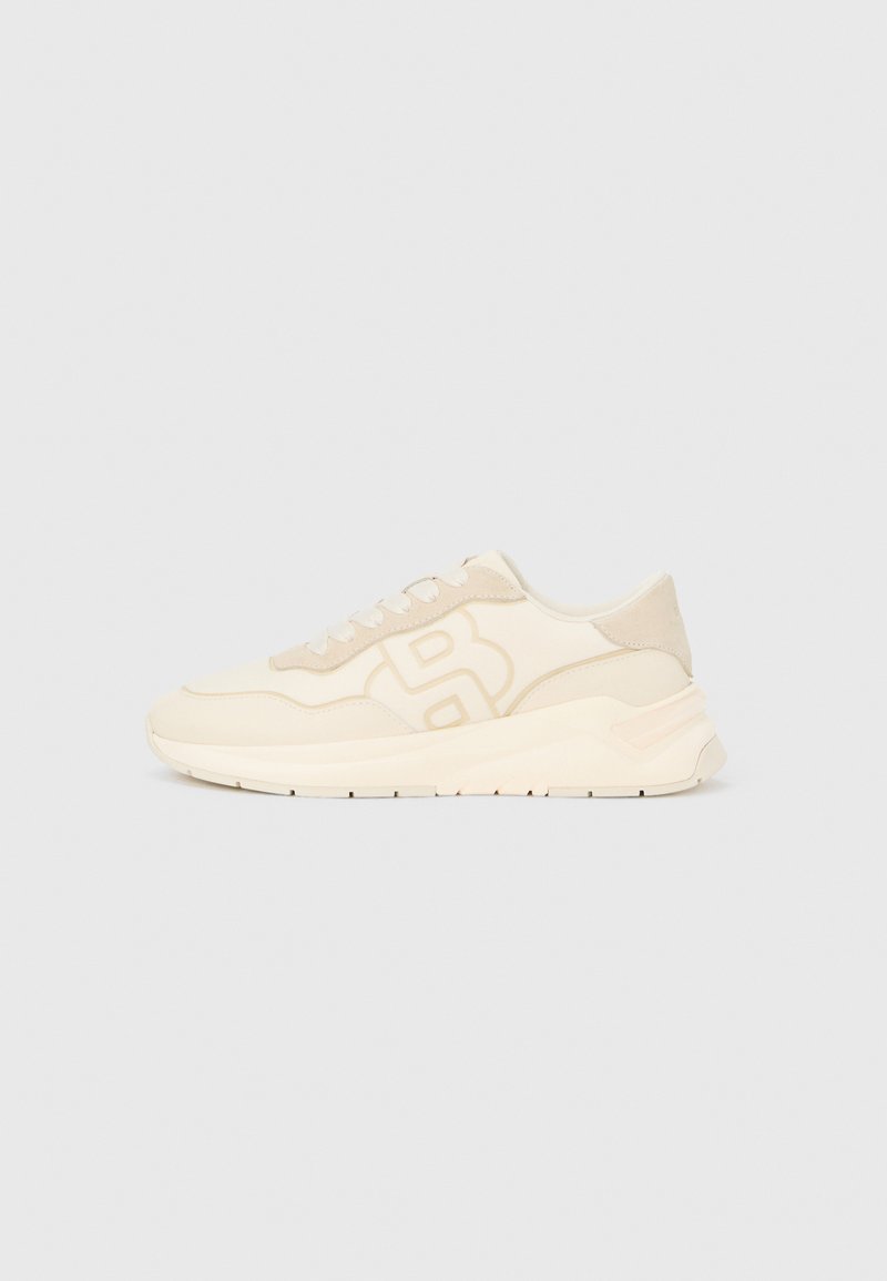 Smėlio spalvos sportiniai batai su lygiu oda ir zomšos tekstūromis, turintys ryškų logotipą, apvalų pirštą ir paminkštintą pado dalį.