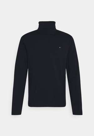 Camiseta negra de manga larga con cuello alto, hecha de tela suave, que presenta un pequeño logotipo en el pecho. Diseño simple y clásico.