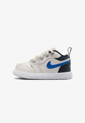 Białe dziecinne sneakersy z niebieskim logo Nike, czarnym obcasem, białą podeszwą i sznurowanym zapięciem, widoczne z boku na białym tle.