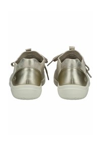 Wsuwane buty z jasnobeżowej tkaniny, z metalicznozłotym obcasem i białą podeszwą. Posiadają teksturowane zapięcie z tyłu oraz dekoracyjne sznurowadła.