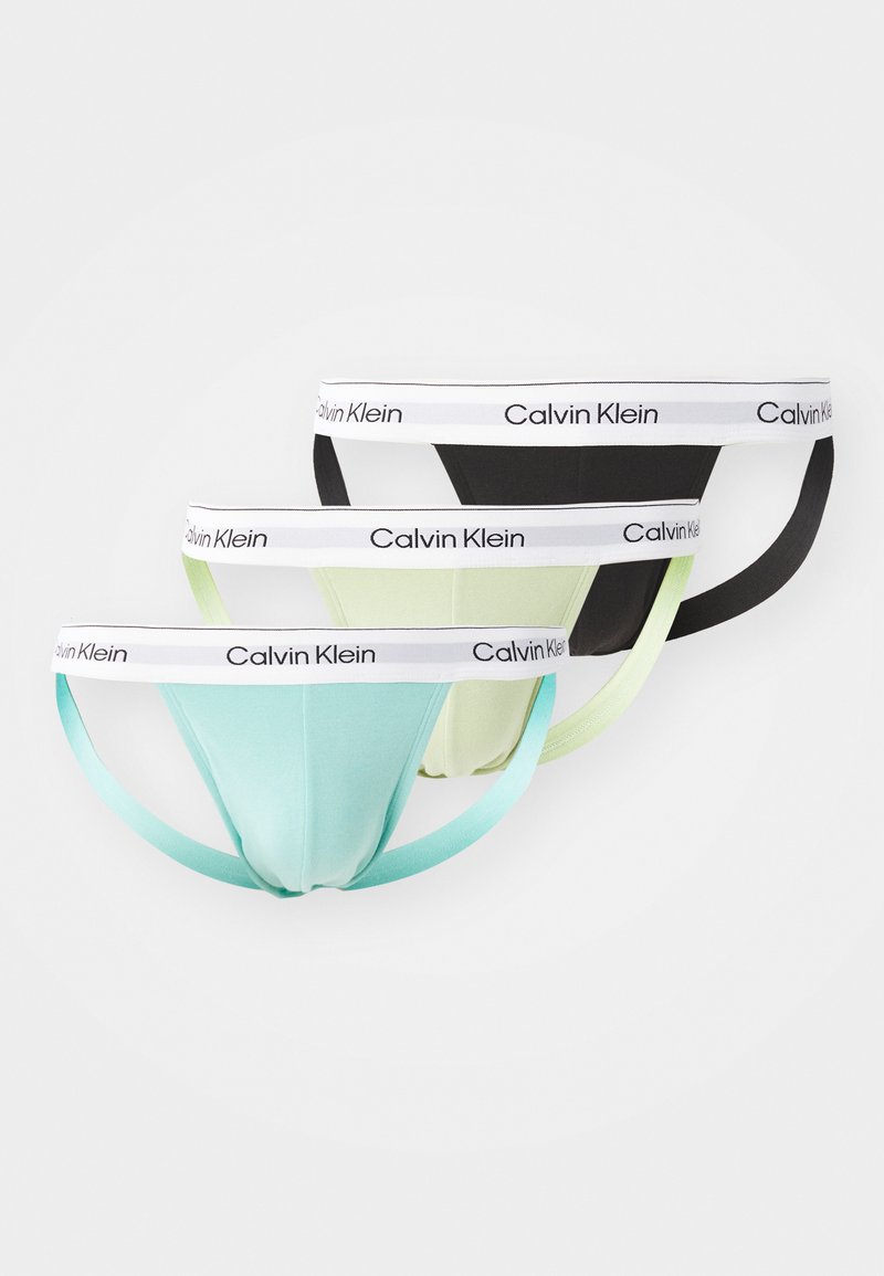 Tre paia di slip Calvin Klein in verde menta, verde chiaro e nero, con un elastico in vita con logo bianco e tessuto morbido.