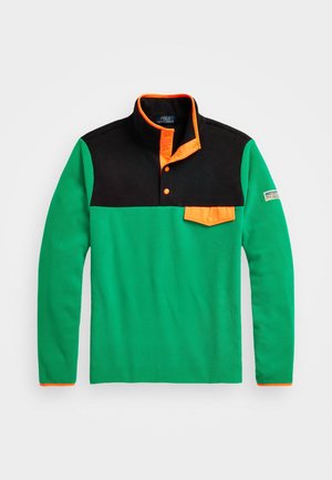 Pulovr s dlouhým rukávem se zeleným tělem, černým horním panelem a oranžovým límcem na patentky a klopou na hrudní kapse.