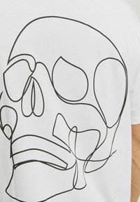 Hvid bomulds t-shirt med et stort sort linje-tegning af et skelet, der fremhæver glatte kurver og minimalistiske designelementer.
