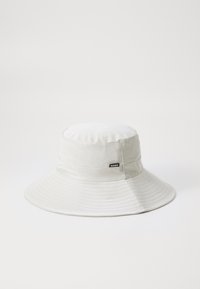 Un chapeau seau en tissu imperméable gris clair, avec un large bord, un motif cousu et un petit logo noir "RAINS" sur le côté.