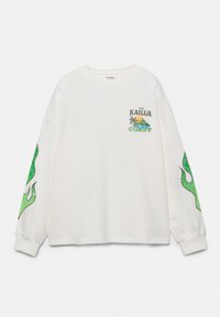 Chemise blanche à manches longues avec des motifs de flammes vertes sur les manches et un petit graphisme sur le thème de la plage « The Kailua Coast » sur la partie supérieure gauche de la poitrine.