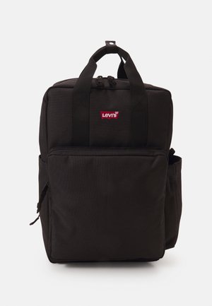 Sac à dos rectangulaire noir avec poche avant zippée, poche latérale, double poignée de portage et logo rouge Levi's sur le panneau avant supérieur.