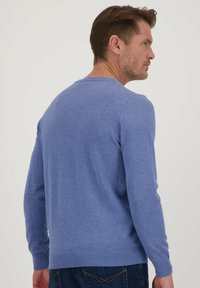 Blauwe heren trui met ronde hals in een zachte gebreide textuur. Heeft lange mouwen en een geribbelde zoom. Eenvoudig ontwerp met minimale afwerking.