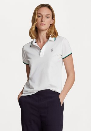 Vit polo tshirt med gröna och marinblå randiga kragekanter, med en liten broderad logotyp på vänster bröst. Slätt tyg, kort ärm.