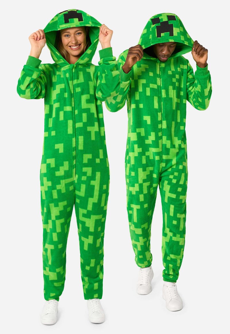 Green fleece onesies with pixelated patterns. Features a hood, front zipper, and ribbed cuffs. Worn by two individuals, one smiling.
