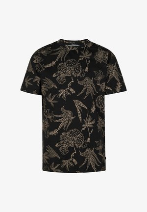 Sort t-shirt med korte ærmer og guldbelagt blomsterprint, kombineret med blå jeans og hvide sneakers. T-shirten har en løs pasform og rund halsudskæring.