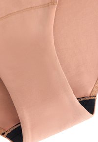 Nacktfarbene nahtlose Stoff-Bralette mit glatter Textur und schwarzen Akzenten. Verfügt über weiche Kanten und minimale Nähte für mehr Komfort.