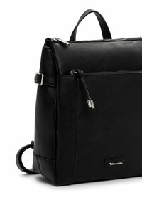 Sac à dos en cuir noir avec une surface texturée, une poignée supérieure, une poche zippée à l'avant et un détail en anneau sur le côté. Éléments en métal argenté.